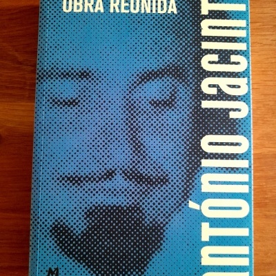 Livro azul com rosto formado por pontos pretos e textos brancos