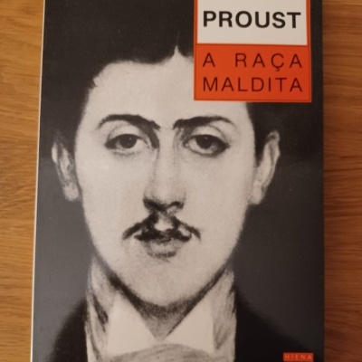 Capa de livro preto e branco com rosto de homem e texto PROUST A RAÇA MALDITA