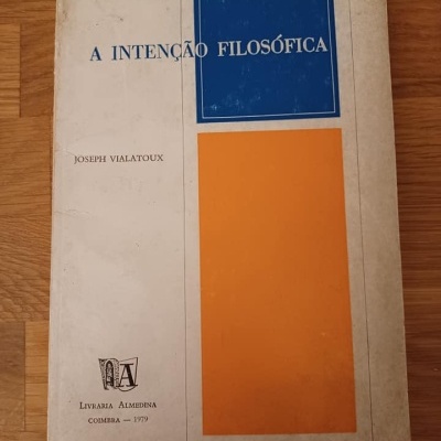 Livro A INTENÇÃO FILOSÓFICA com capa branca, azul e laranja sobre chão de madeira