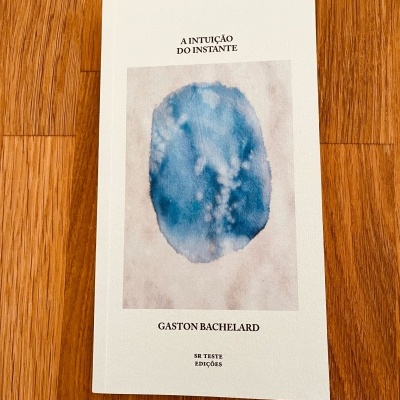 Livro 'A INTUIÇÃO DO INSTANTE' de Gaston Bachelard com capa branca e ilustração azul