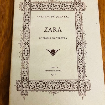 Capa de livro antigo com texto e ornamentos em castanho sobre fundo creme