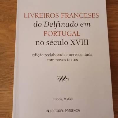 Livro branco com título em português na capa sobre uma mesa de madeira
