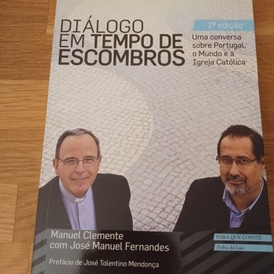 Capa de livro 'Diálogo em Tempo de Escombros' com foto de duas pessoas e texto informativo.