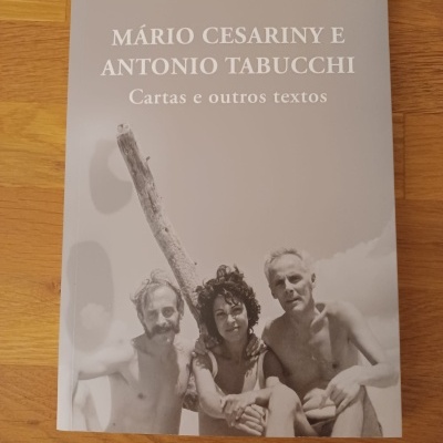 Capa de livro cinza com fotografia em preto e branco de três pessoas e título em branco