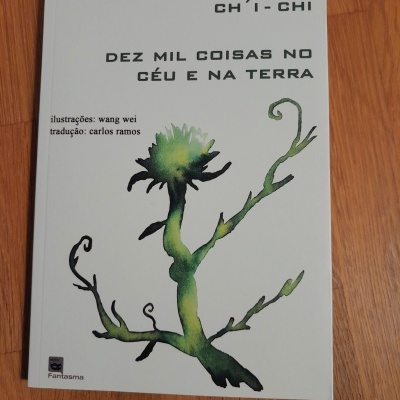 Livro branco com título e ilustração de planta verde preto, sobre madeira.