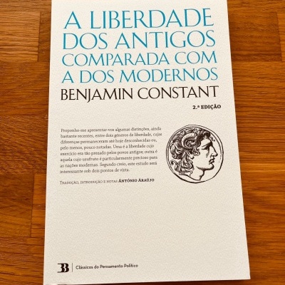 Capa de livro branca com texto azul e preto e ilustração circular de perfil clássico