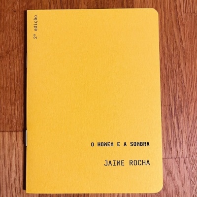 Livro amarelo com texto O HOMEM E A SOMBRA e JAIME ROCHA, 2ª edição.