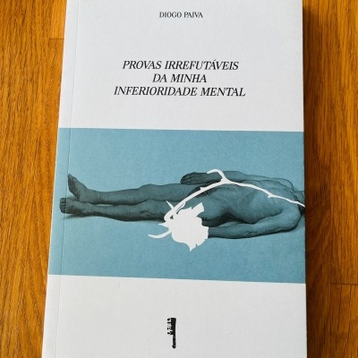 Livro capa branca e azul com texto e imagem de corpo humano deitado