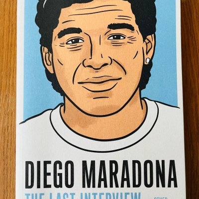 Capa de livro branca com desenho e texto sobre Diego Maradona