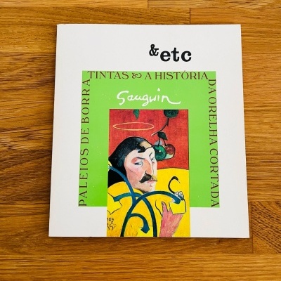 Livro com capa branca e ilustração colorida central com texto e assinatura Gauguin