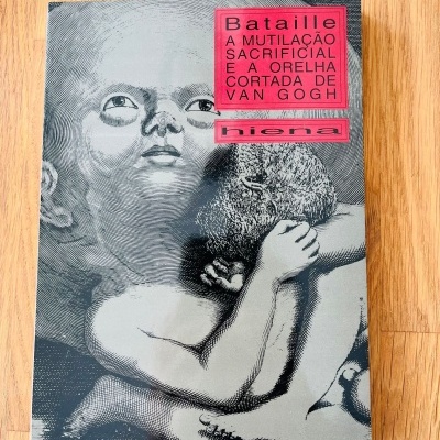 Livro com capa ilustrada a preto e branco com texto em fundo vermelho