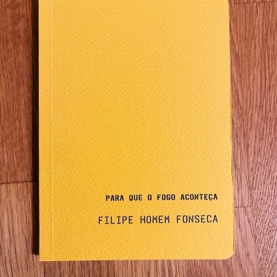 Caderno amarelo com texto preto sobre superfície de madeira clara