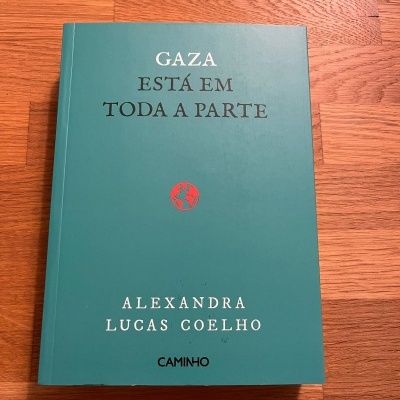 Livro 'GAZA ESTÁ EM TODA A PARTE' em capa verde sobre madeira