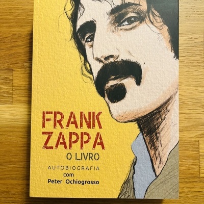 Livro Frank Zappa com capa amarela e retrato ilustrado de homem com bigode
