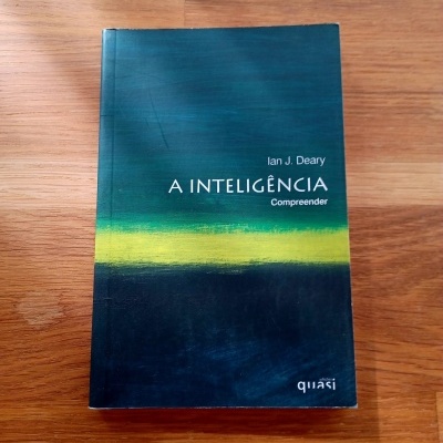 Livro 'A INTELIGÊNCIA Compreender' de Ian J. Deary sobre mesa de madeira