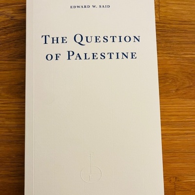 Capa branca do livro THE QUESTION OF PALESTINE em fundo de madeira.