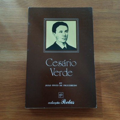 Livro 'Cesário Verde' de capa castanha com retrato a preto e branco sobre superfície de madeira.