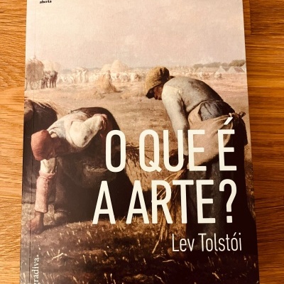 Capa de livro 'O QUE É A ARTE?' de Lev Tolstói com imagem de trabalhadores rurais no campo