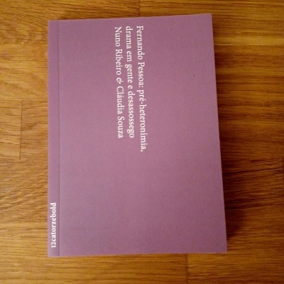 Livro lilás com texto branco sobre mesa de madeira