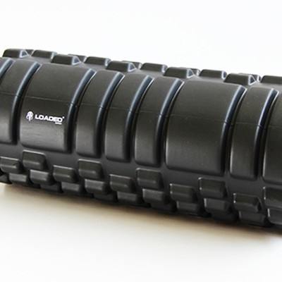 Rolo de espuma preto para massagens musculares com textura em blocos e texto LOADED.