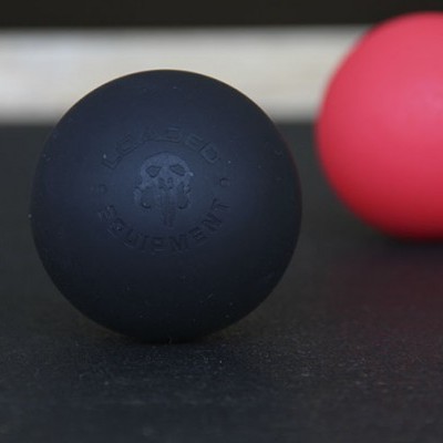 Bolas de massagem preta e vermelha sobre superfície escura