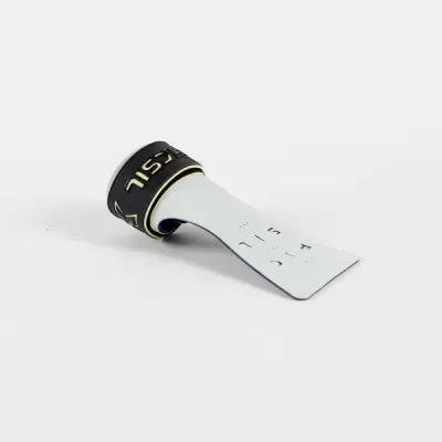 Etiqueta branca com texto e fita preta com letras douradas sobre fundo branco