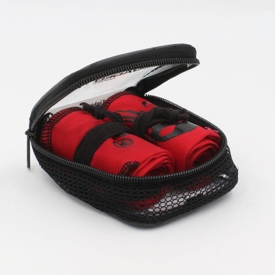 Estojo preto de malha aberto com dois tecidos vermelhos enrolados dentro.