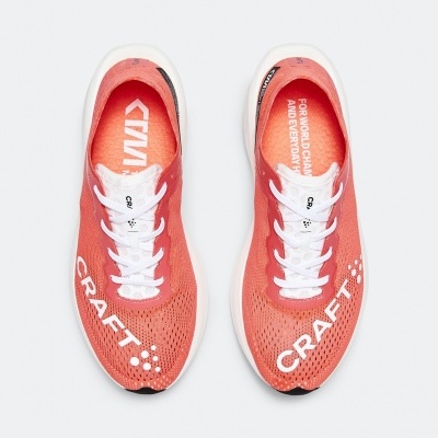 Par de sapatilhas de corrida coral com detalhes brancos e logo CRAFT.