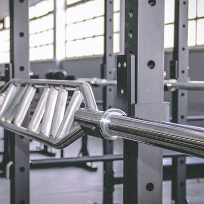 Barra hexagonal cromada num suporte metálico num ginásio