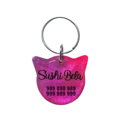 Chaveiro em forma de cabeça de gato rosa e roxo com texto preto e argola metálica