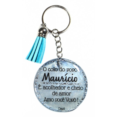 Chaveiro redondo transparente com texto em português e tassel azul claro