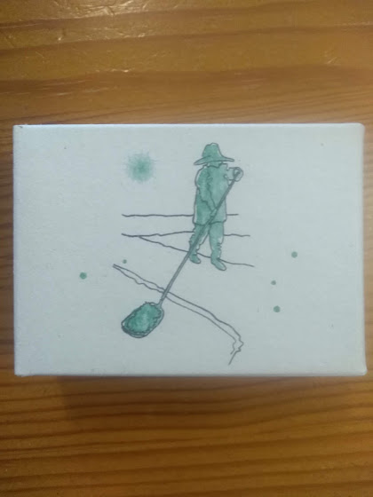 Caixa branca com ilustração de pessoa e vara em verde e preto