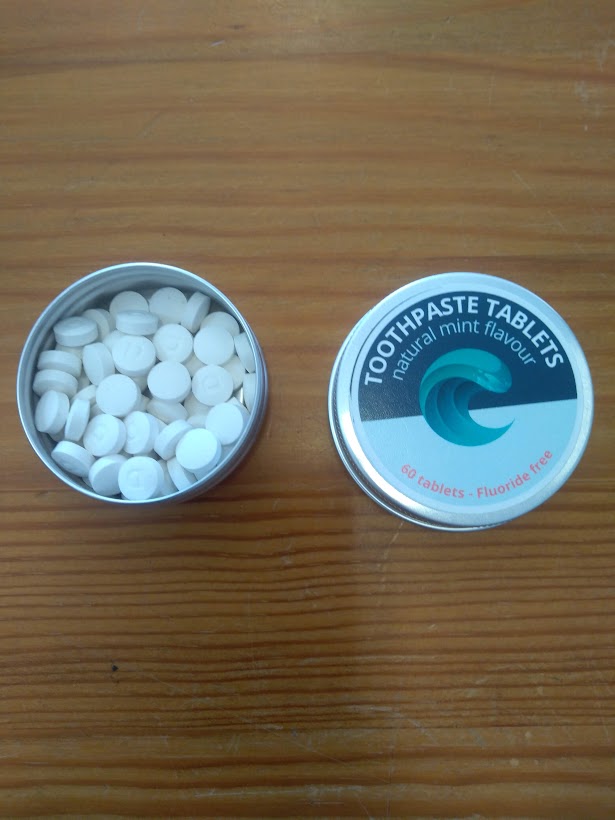 Latas pequenas com pastilhas brancas e rótulo TOOTHPASTE TABLETS