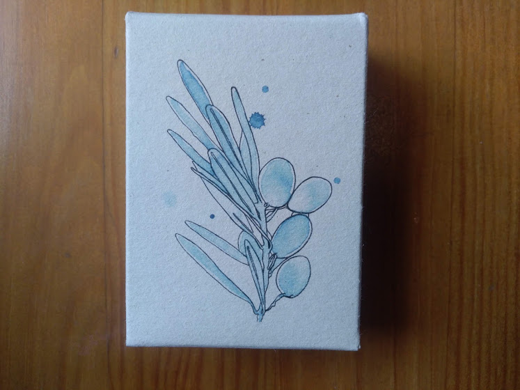 Caixa de papel com desenho de ramo azul cinza sobre madeira clara