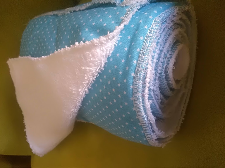 Rolo de tecido azul com estrelas brancas e tecido felpudo branco