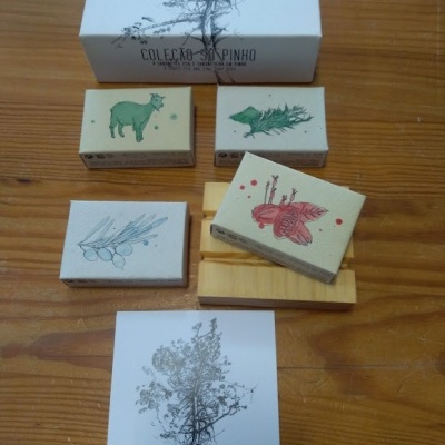 Conjunto de sabonetes artesanais com ilustrações de animais e plantas sobre superfície de madeira.