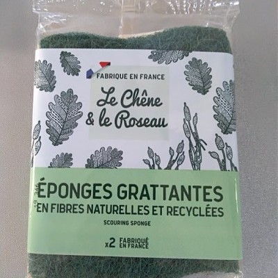 Esponjas verdes abrasivas em embalagem transparente com rótulo branco e verde e desenhos de folhas.