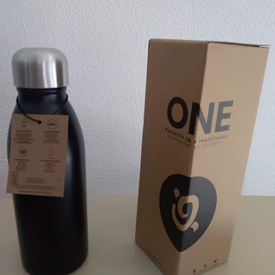 Garrafa térmica preta com tampa prateada ao lado de embalagem castanha com texto ONE e símbolo em coração preto