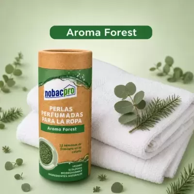 Embalagem de perlas perfumadas para roupa nobacpro Aroma Forest sobre toalhas brancas e folhas verde