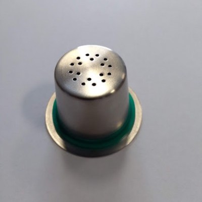 Cápsula de café metálica reutilizável prateada com anel verde em fundo branco