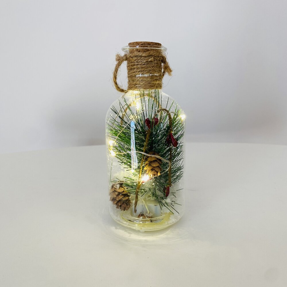 Garrafa decorativa de vidro com pinhas, ramos verdes e luzes LED