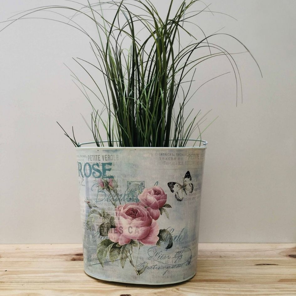Vaso metálico decorativo com estampa floral e planta verde