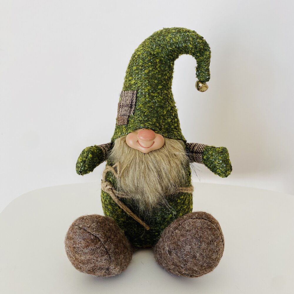 Gnomo decorativo com chapéu verde, barba comprida e pés castanhos sentado