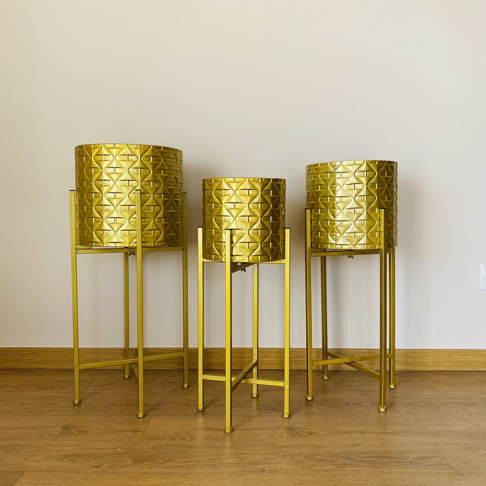 Suportes dourados para plantas em metal com textura geométrica