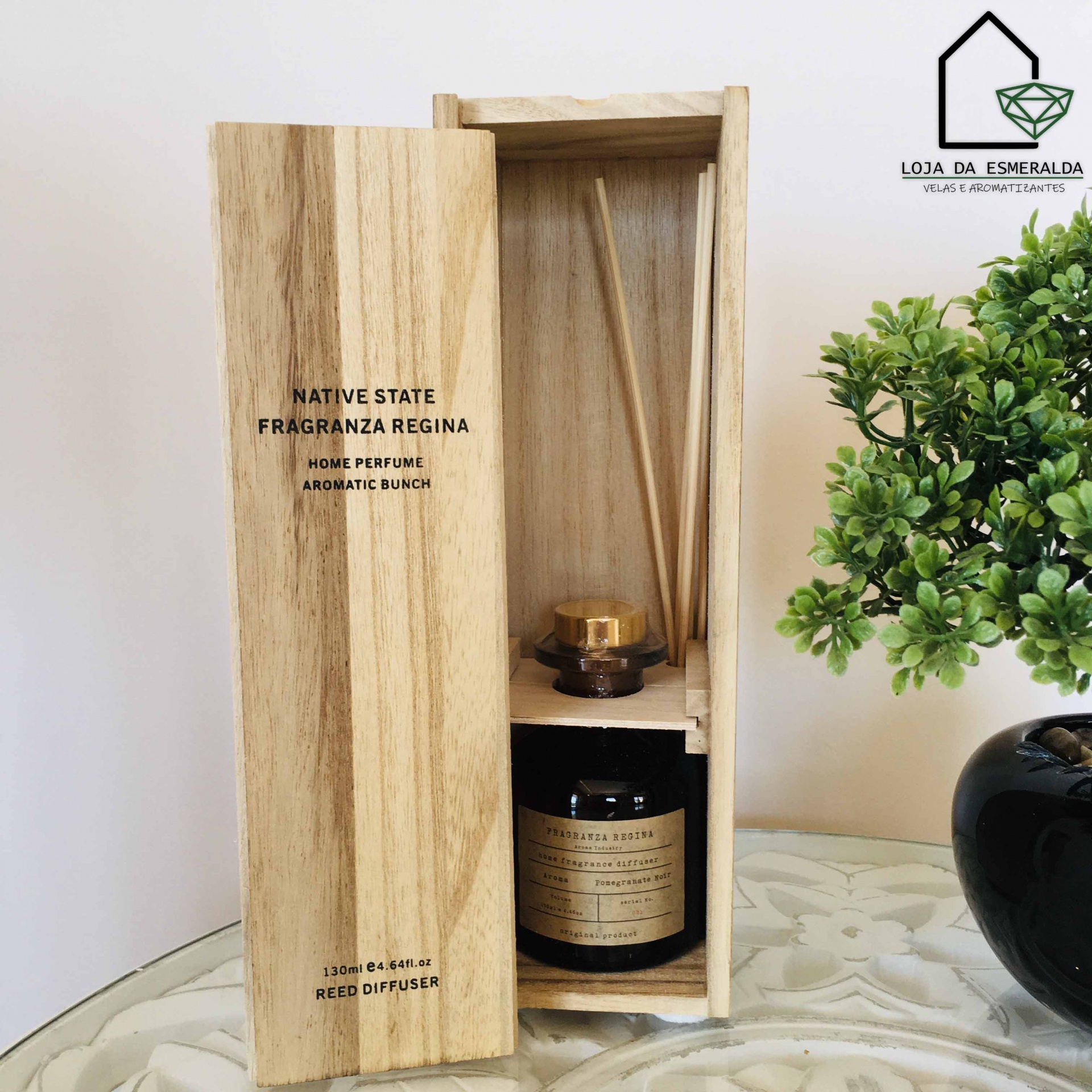 Difusor de varetas em caixa de madeira com planta verde em vaso preto