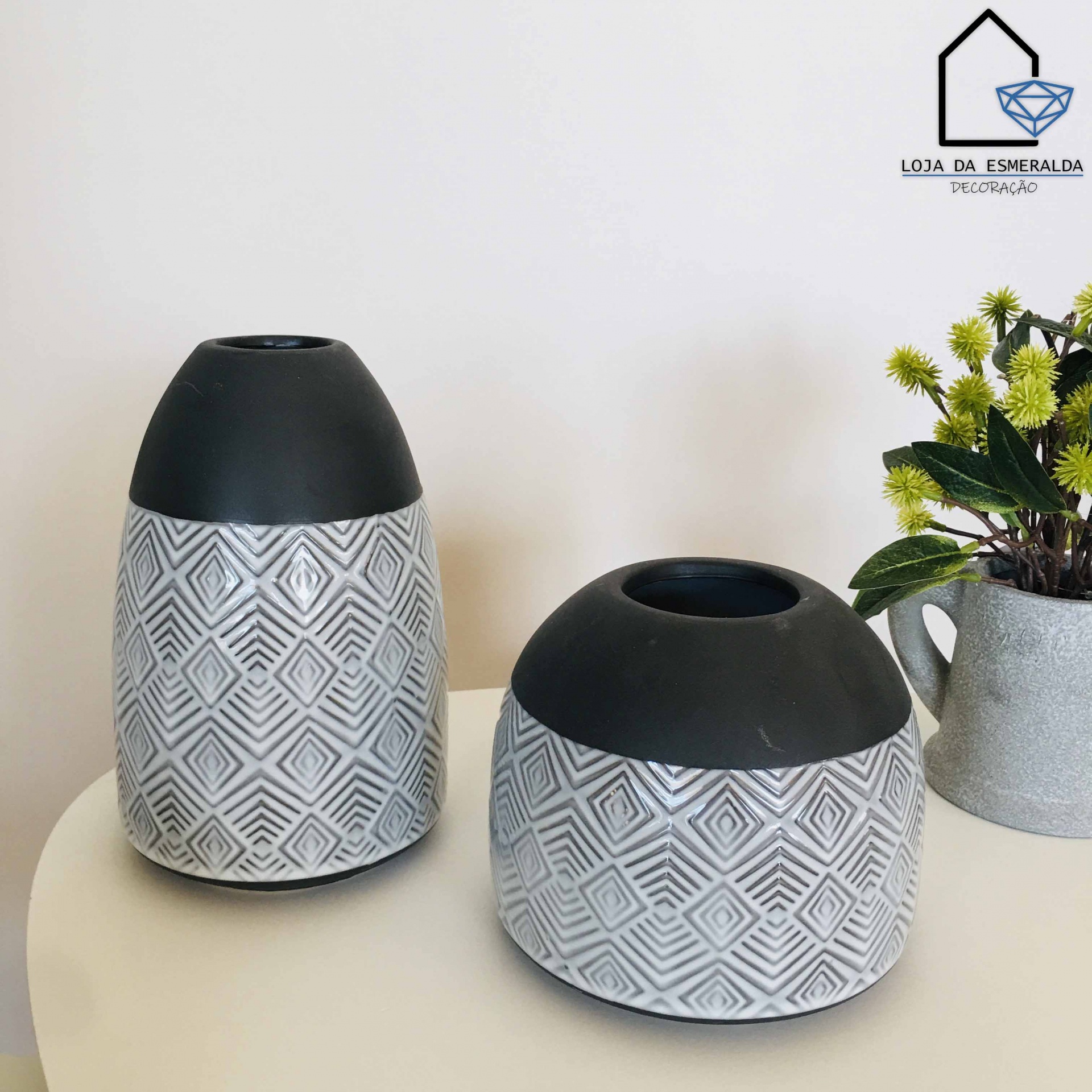 Dois vasos decorativos brancos e pretos com padrões geométricos num ambiente interior