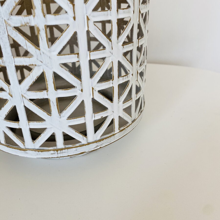Objeto decorativo cilíndrico branco com padrão geométrico recortado