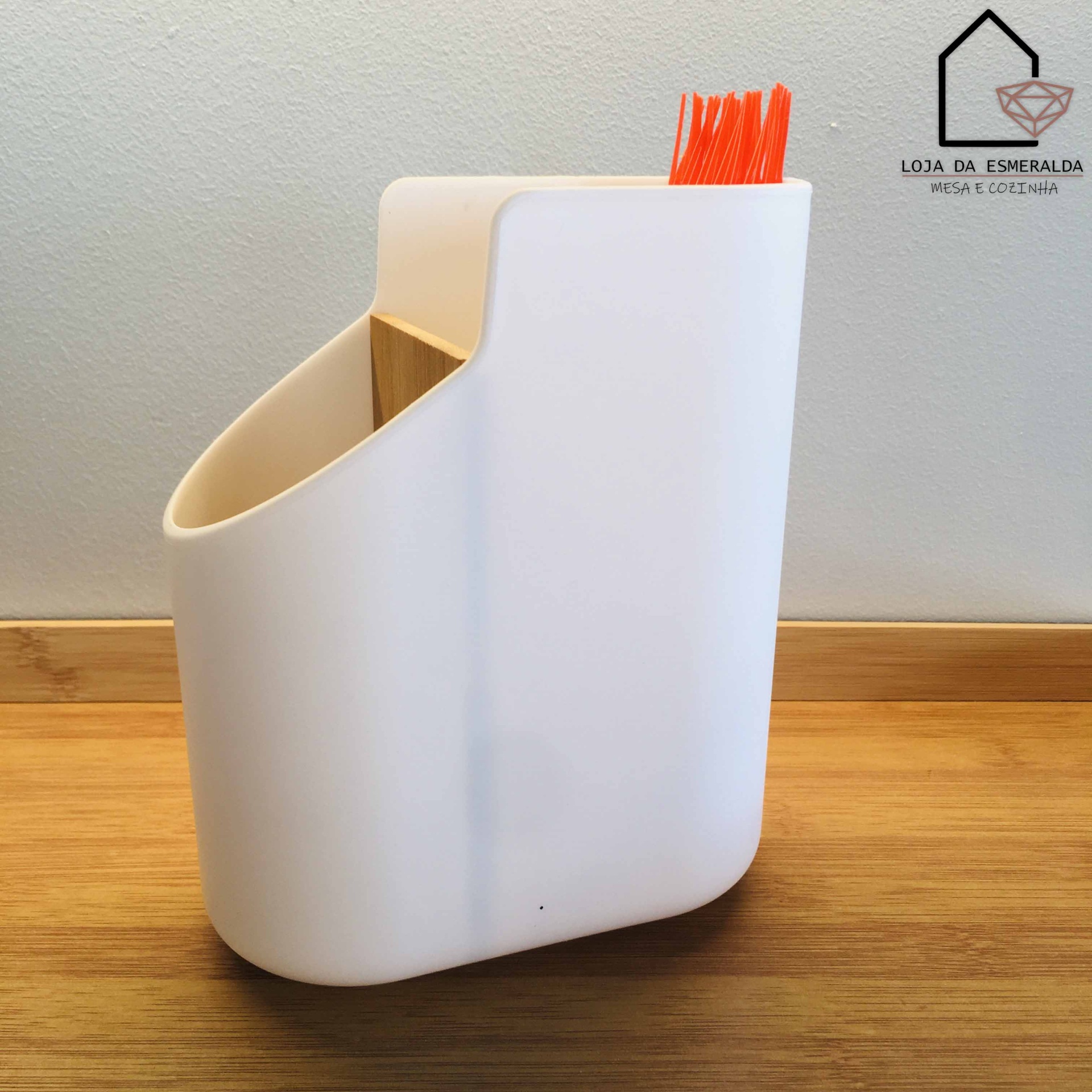 Organizador de utensílios de cozinha branco com compartimentos e detalhes em madeira, em fundo de madeira e parede cinza