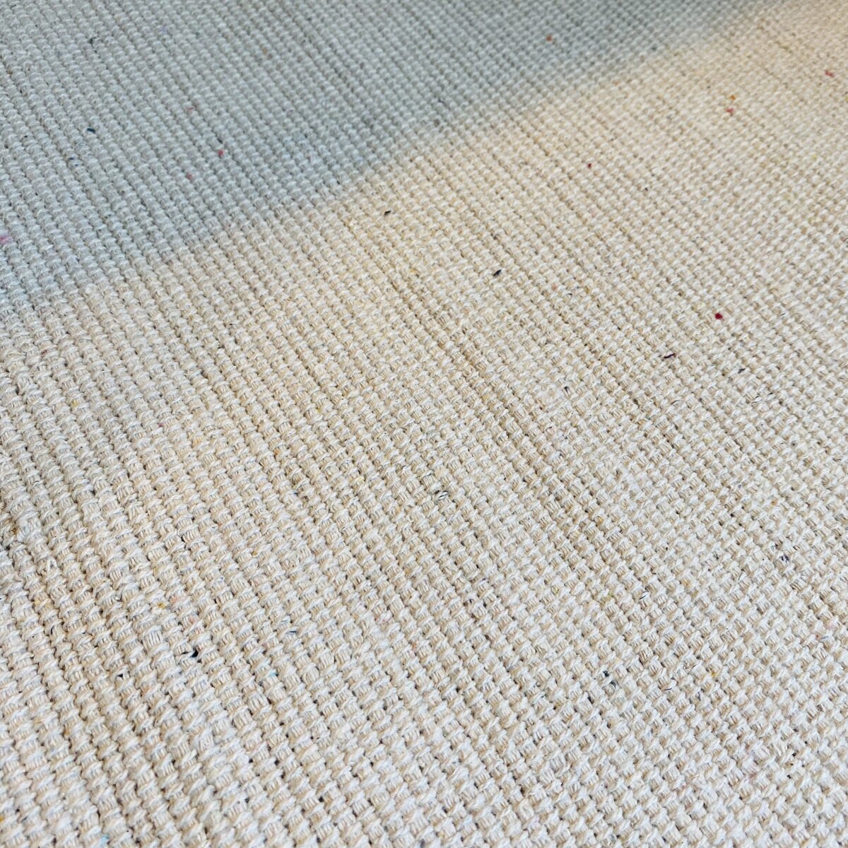 Tapete bege claro com pequenos pontos coloridos e textura visível