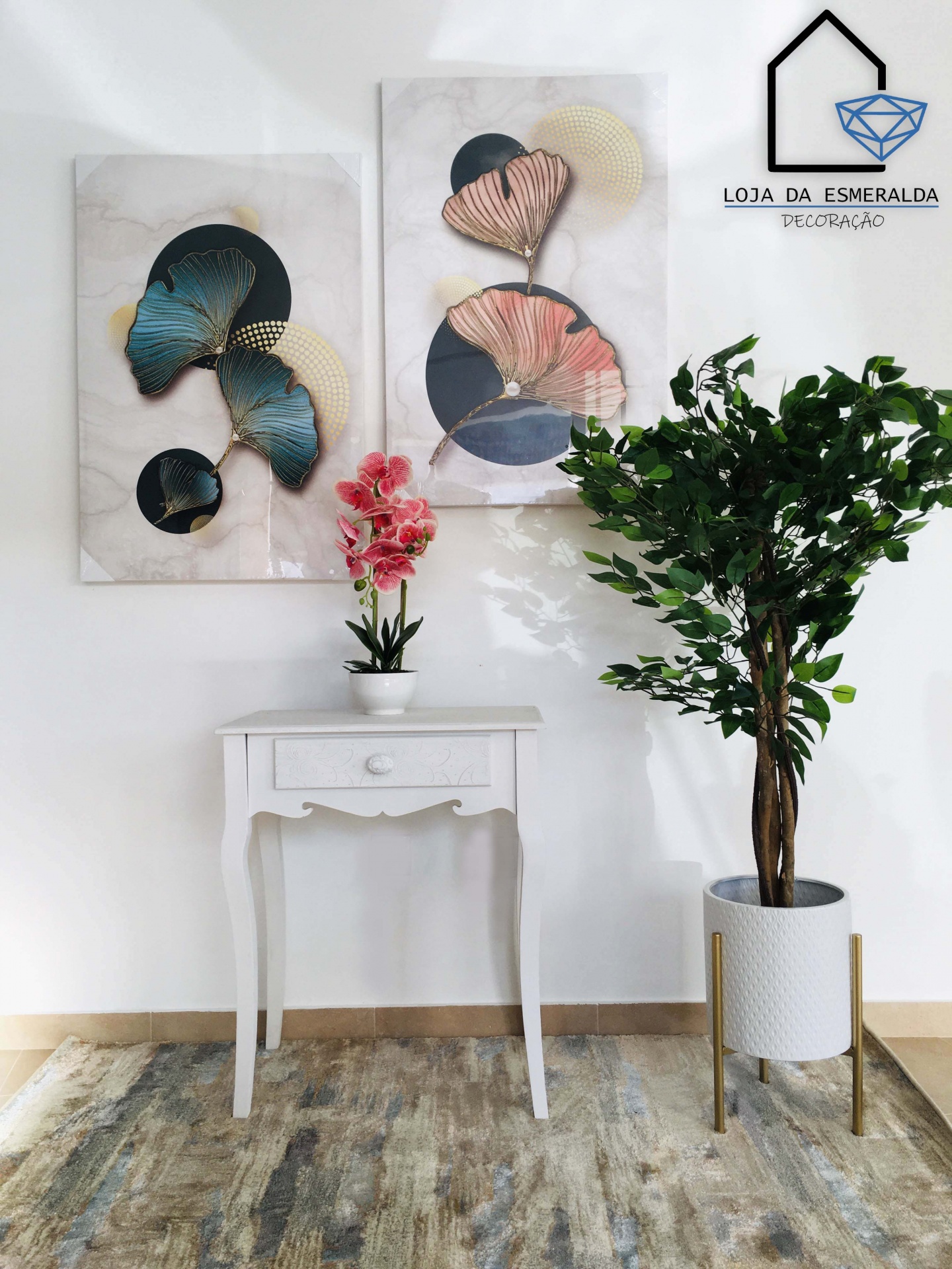 Mesa branca com vaso de flores cor-de-rosa, planta em vaso branco, quadros abstratos e tapete claro